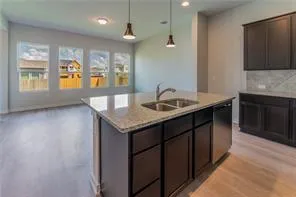 a kitchen with granite countertop kitchen island a sink a stove and a window