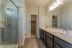 15107 Ryman Road Pflugerville, TX 78660 - Photo 10 of 34 a bathroom with a double vanity sink and mirror