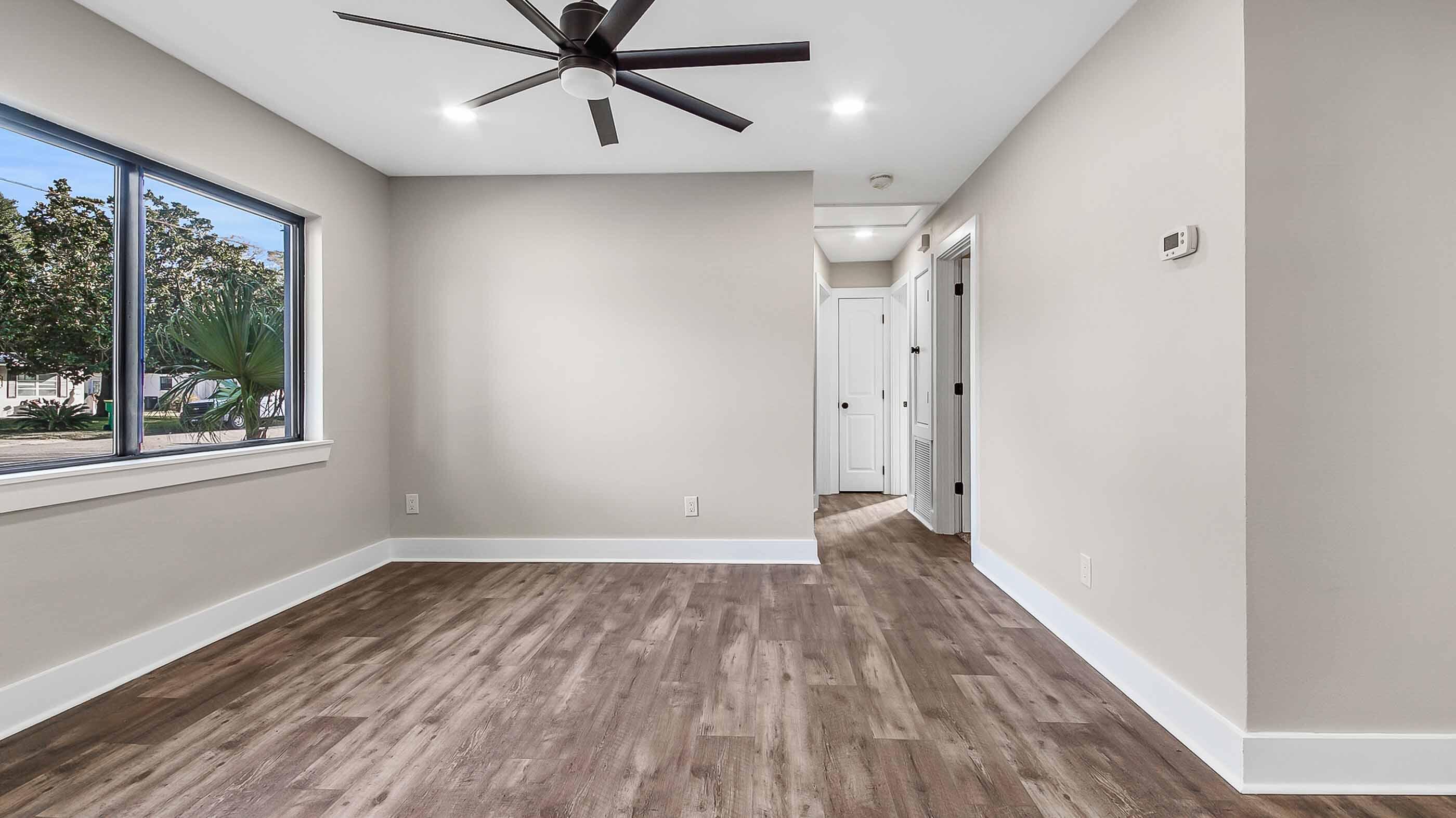 415 Avon Lane Mary Esther, FL 32569 - Photo 13 of 40 a view of an empty room with wooden floor and a window