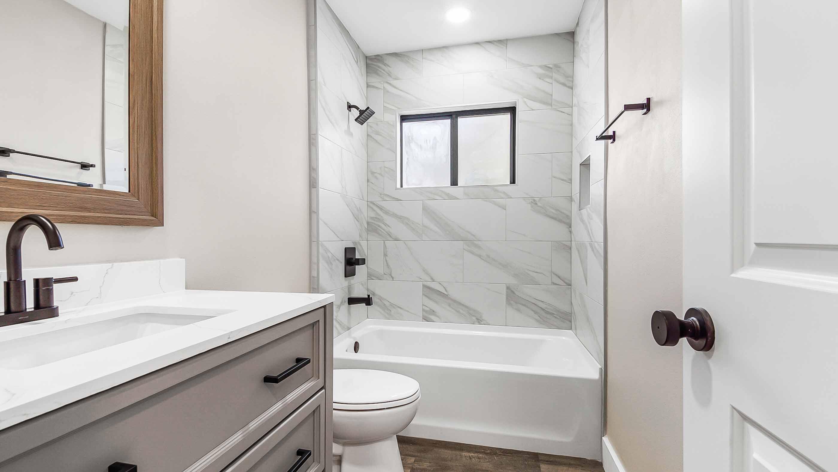 415 Avon Lane Mary Esther, FL 32569 - Photo 16 of 40 a bathroom with a sink a toilet a mirror and bathtub