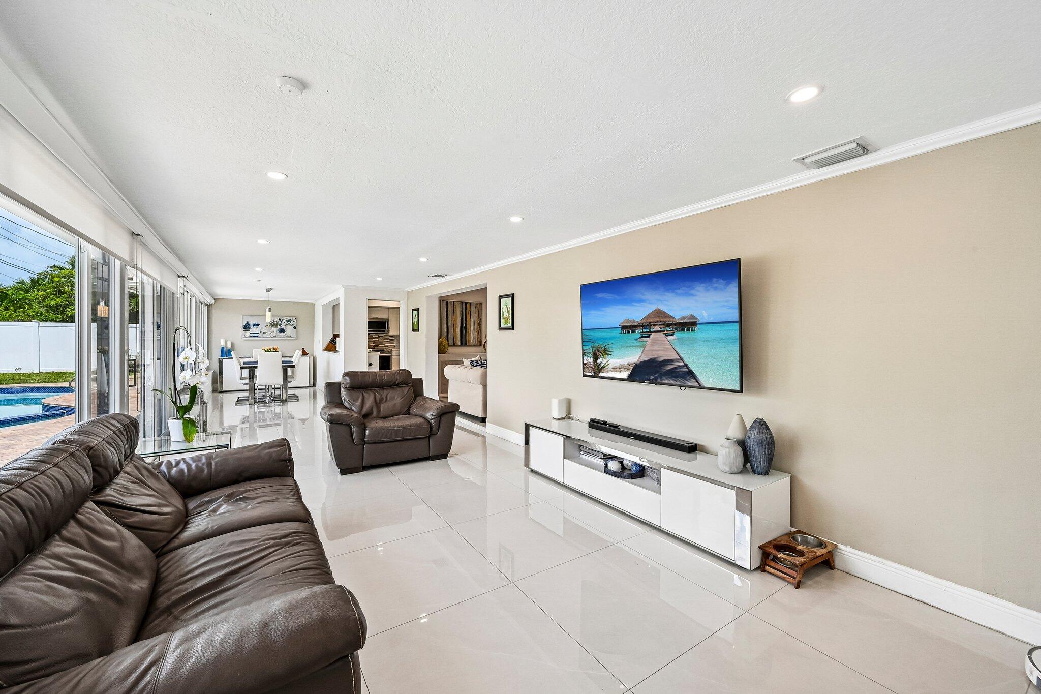 2940 Northeast 39th Court Lighthouse Point, FL 33064 - Photo 16 of 42 a living room with furniture gym equipment and a flat screen tv