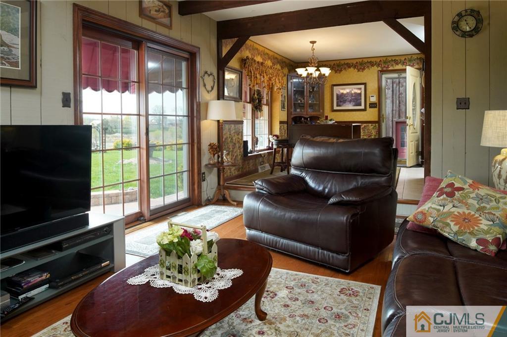270 Croshaw Road Wrightstown, NJ 08562 - Photo 9 of 24 a living room with furniture a flat screen tv and a floor to ceiling window