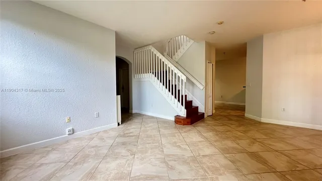 a kitchen with stainless steel appliances granite countertop a refrigerator a stove and a sink with wooden cabinets