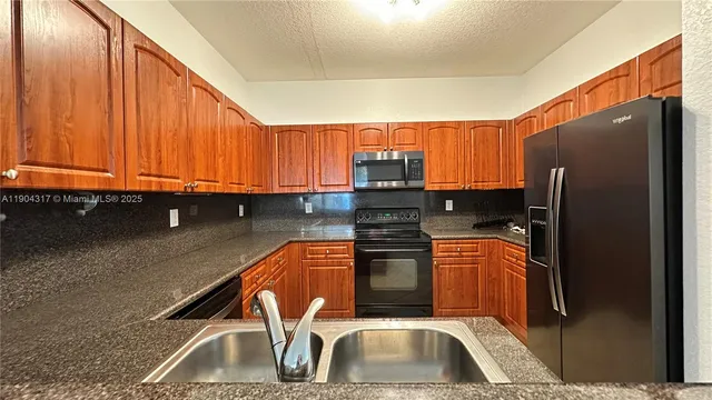 a kitchen with stainless steel appliances granite countertop a sink stove and microwave