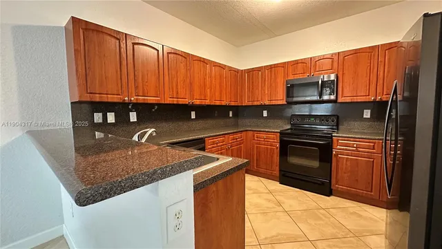 a kitchen with granite countertop a stove a microwave and a sink