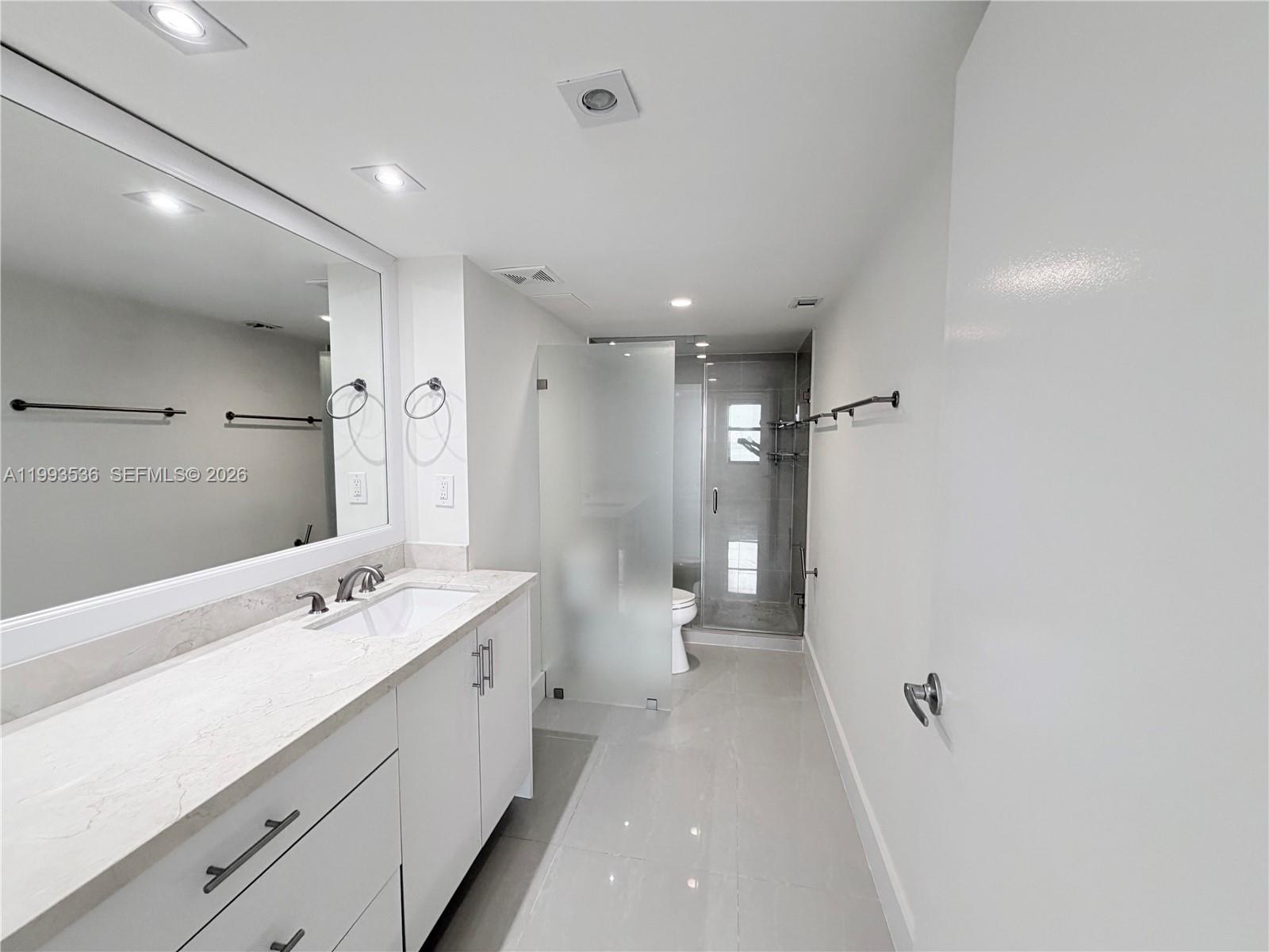 2333 Brickell Avenue, Unit 1407 Miami, FL 33129 - Photo 11 of 38 a bathroom with a double vanity sink and mirror with toilet