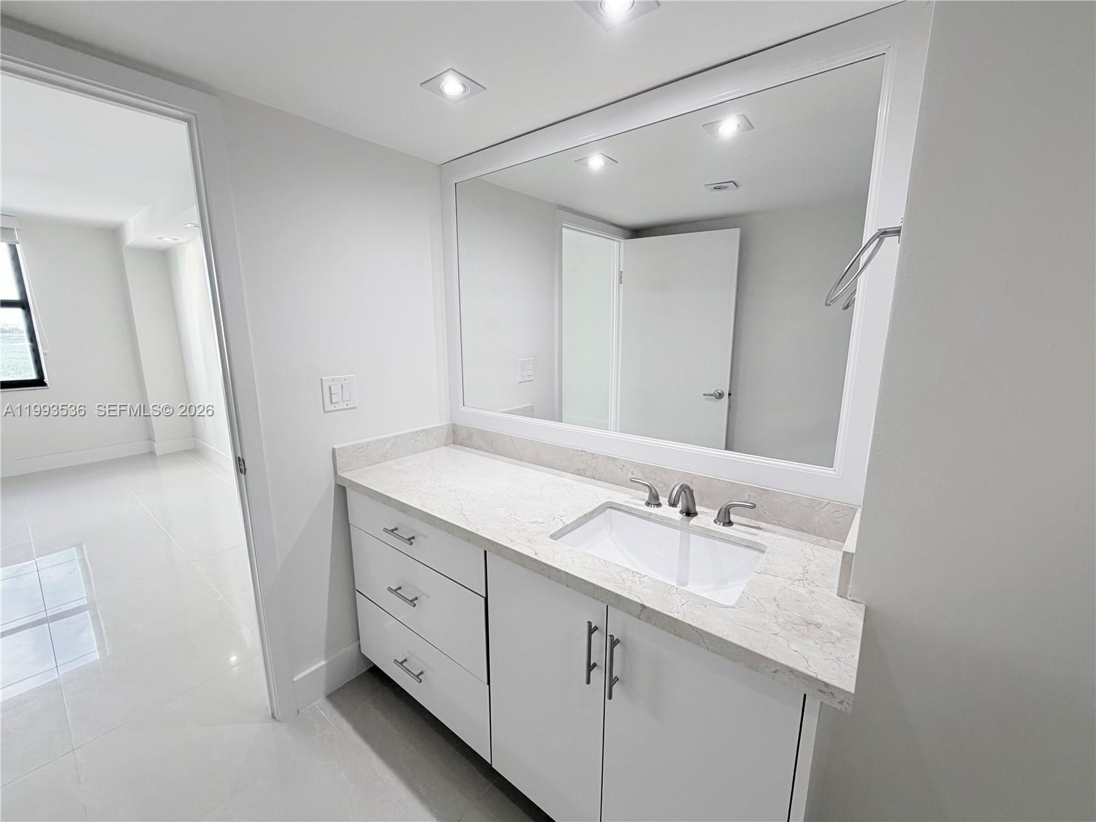 2333 Brickell Avenue, Unit 1407 Miami, FL 33129 - Photo 12 of 38 a bathroom with a granite countertop sink double and mirror