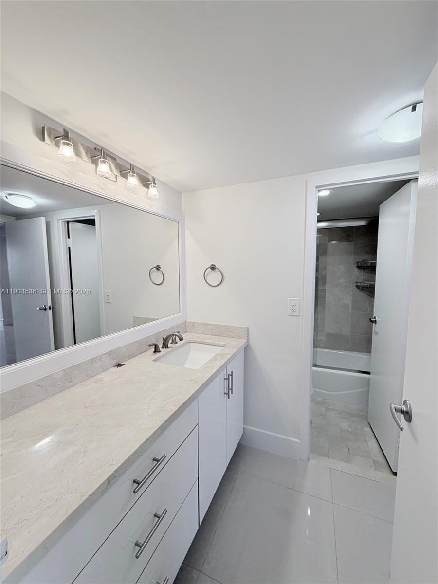 2333 Brickell Avenue, Unit 1407 Miami, FL 33129 - Photo 20 of 38 a spacious bathroom with a granite countertop sink and a mirror