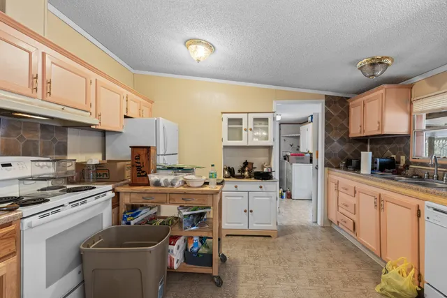 a kitchen with cabinets a sink and white stainless steel appliances