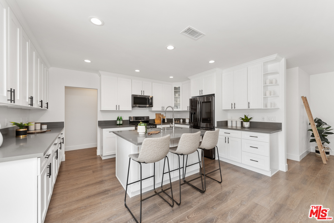 2223 North Keystone Street Burbank, CA 91504 - Photo 4 of 17 a kitchen with white cabinets and stainless steel appliances