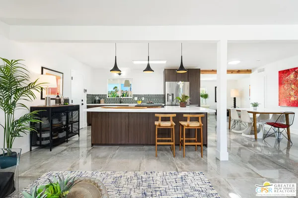 a kitchen with kitchen island a stove a table and chairs in it
