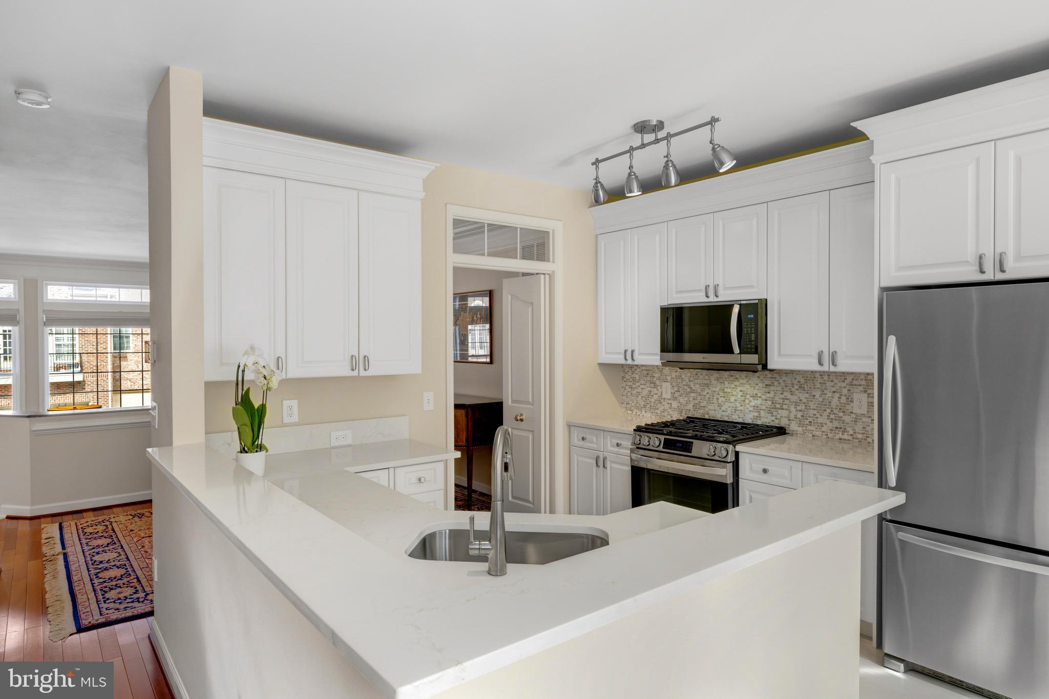 1916 Logan Manor Drive Reston, VA 20190 - Photo 36 of 56 a kitchen with stainless steel appliances a refrigerator a stove a microwave and cabinets