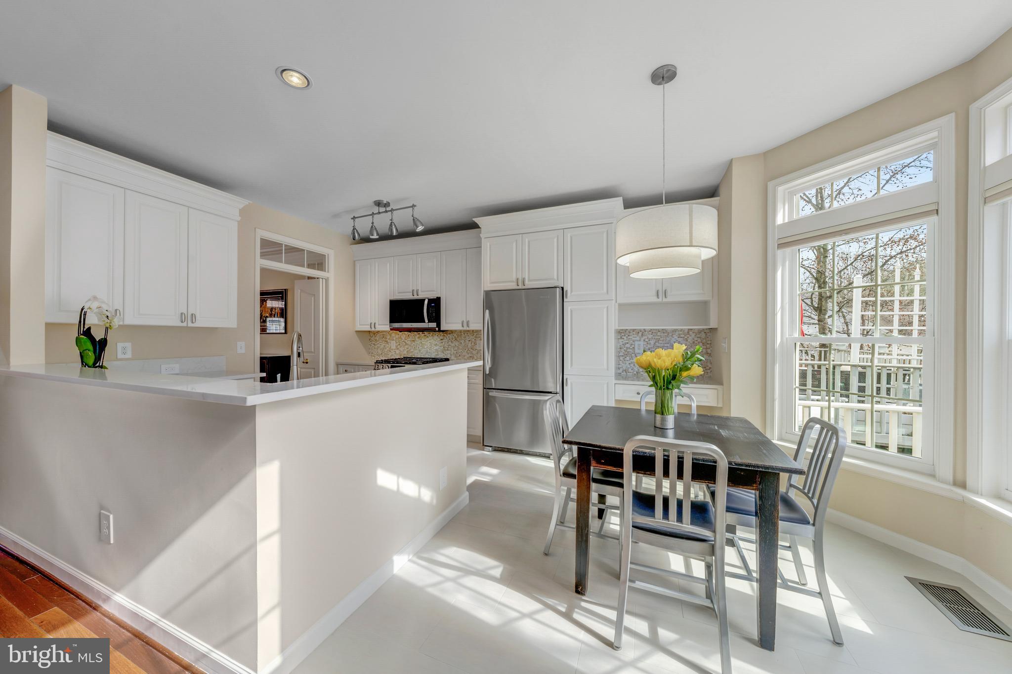 1916 Logan Manor Drive Reston, VA 20190 - Photo 4 of 56 a kitchen with a dining table chairs and refrigerator