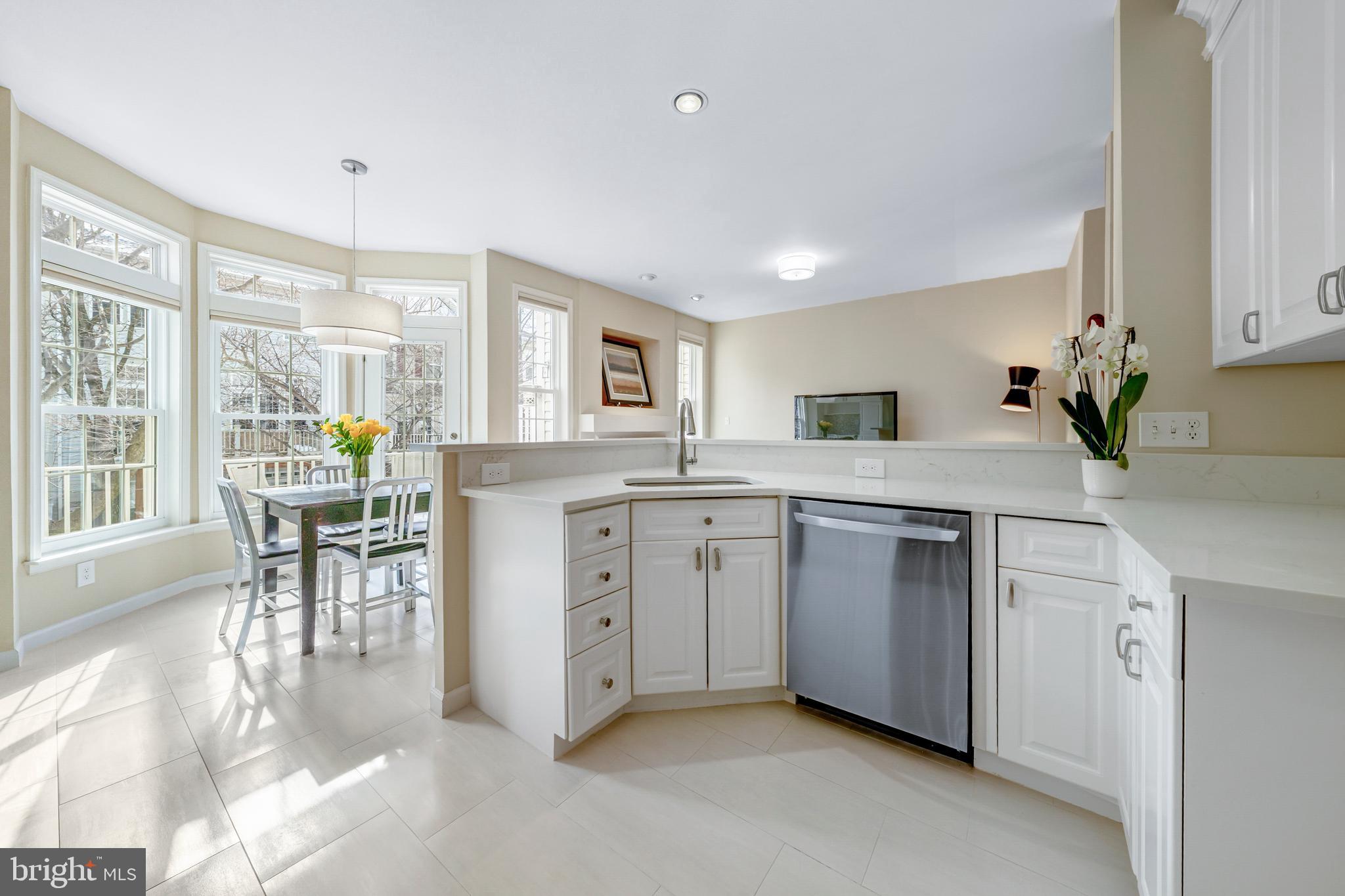 1916 Logan Manor Drive Reston, VA 20190 - Photo 5 of 56 a kitchen with white cabinets and wooden floor