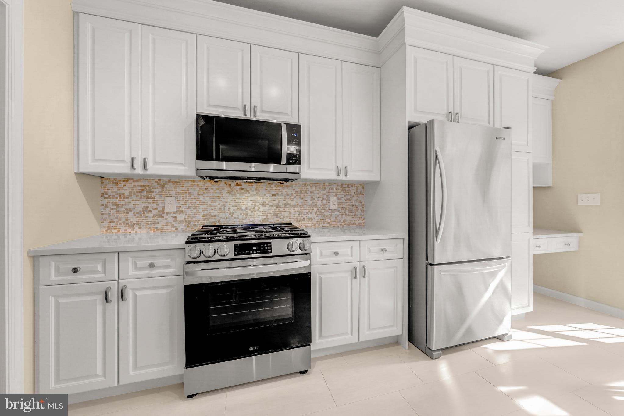 1916 Logan Manor Drive Reston, VA 20190 - Photo 7 of 56 a kitchen with stainless steel appliances white cabinets and a stove top oven