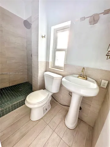 a bathroom with a toilet sink and mirror