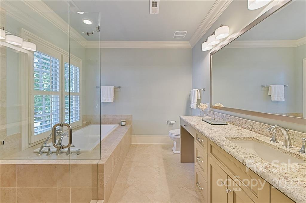 1951 Harris Road Charlotte, NC 28211 - Photo 26 of 35 a bathroom with a granite countertop sink a large mirror and a bathtub
