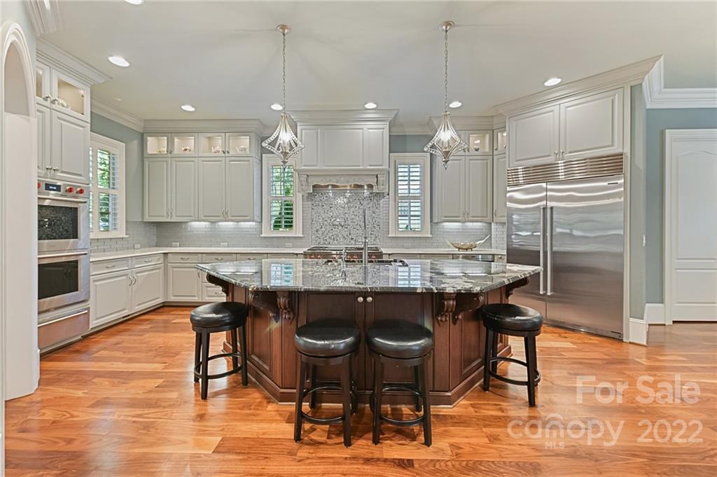 1951 Harris Road Charlotte, NC 28211 - Photo 7 of 35 a kitchen with stainless steel appliances kitchen island granite countertop a dining table chairs and sink