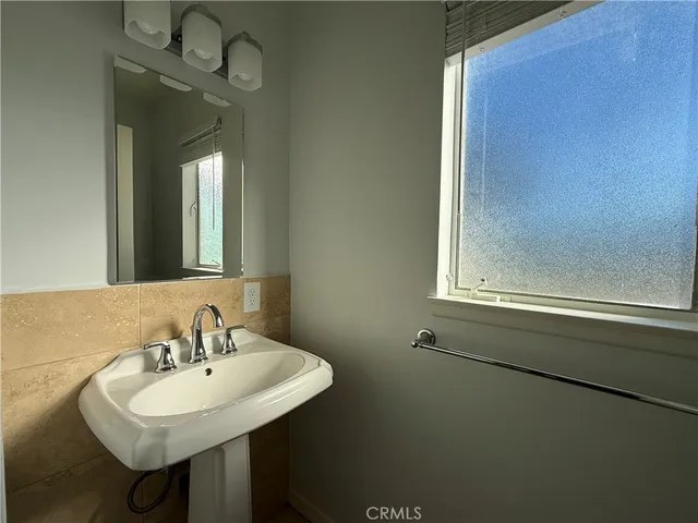 a bathroom with a sink a mirror and a window