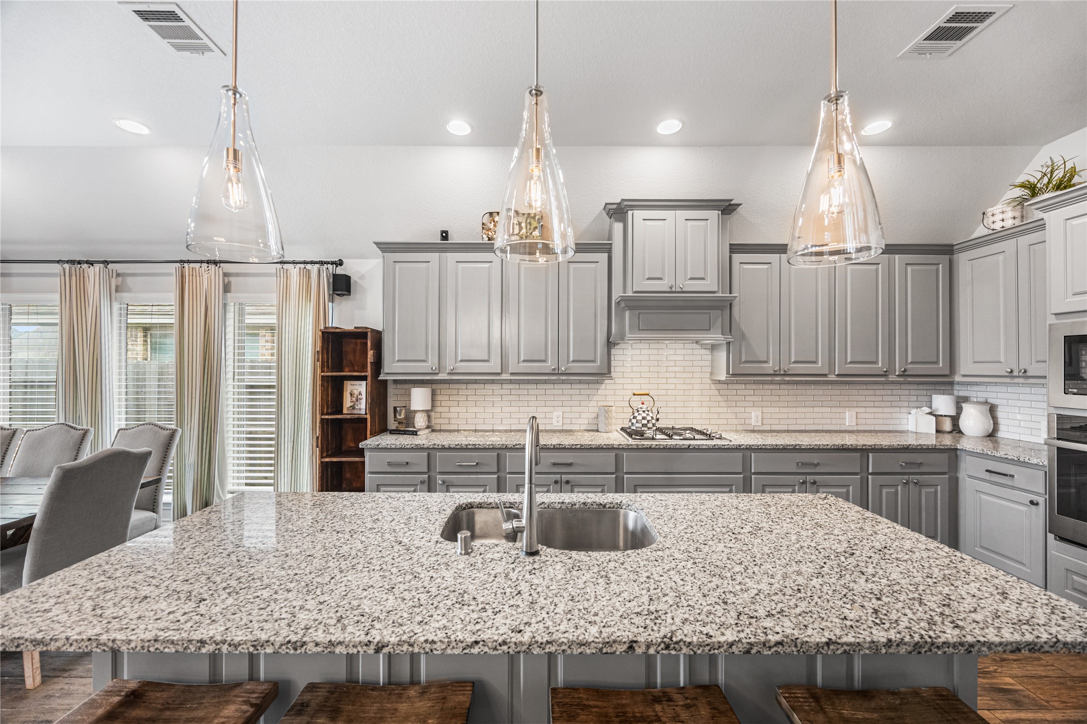 28169 Knight Peak Drive Spring, TX 77386 - Photo 8 of 33 a kitchen with stainless steel appliances granite countertop a sink a stove and a wooden cabinets