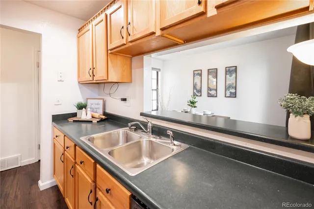 a kitchen with stainless steel appliances granite countertop a sink a stove and a wooden cabinets