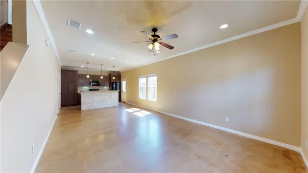 wooden floor in an empty room with a kitchen