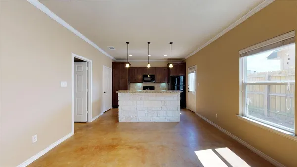 a living room with stainless steel appliances kitchen island granite countertop furniture and a large window