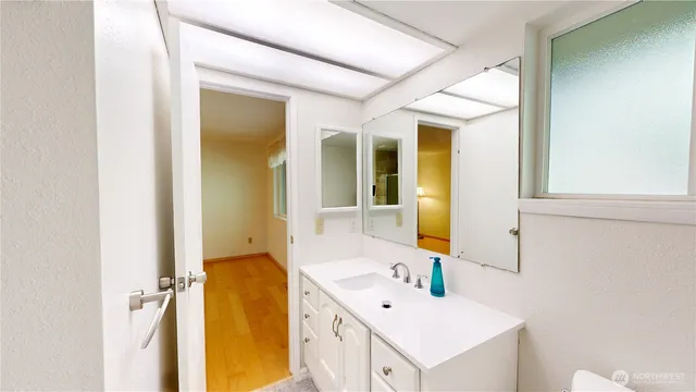a bathroom with a sink mirror and tub