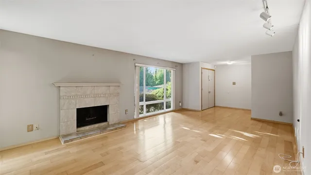a view of empty room with wooden floor and fireplace