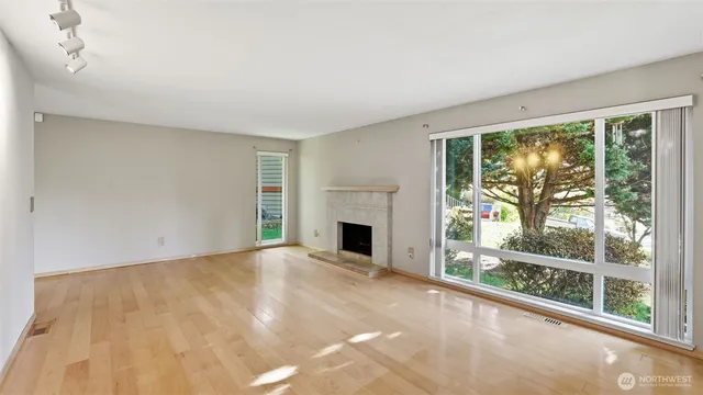 a view of an empty room with a fireplace and a window