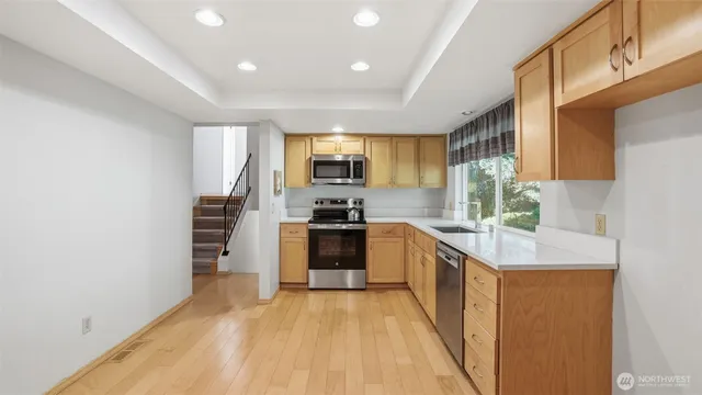 a kitchen with stainless steel appliances granite countertop a stove a sink and a refrigerator