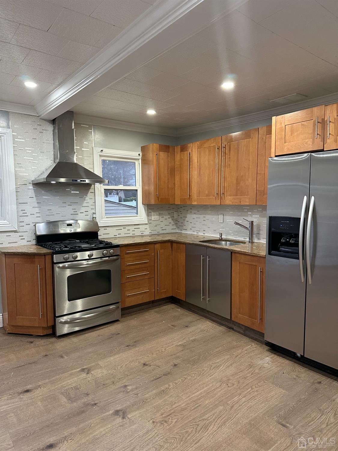 a kitchen with stainless steel appliances granite countertop a stove a sink and a refrigerator