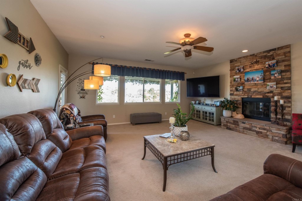 28288 Deep Canyon Drive Escondido, CA 92026 - Photo 12 of 75 a living room with furniture a fireplace and a flat screen tv