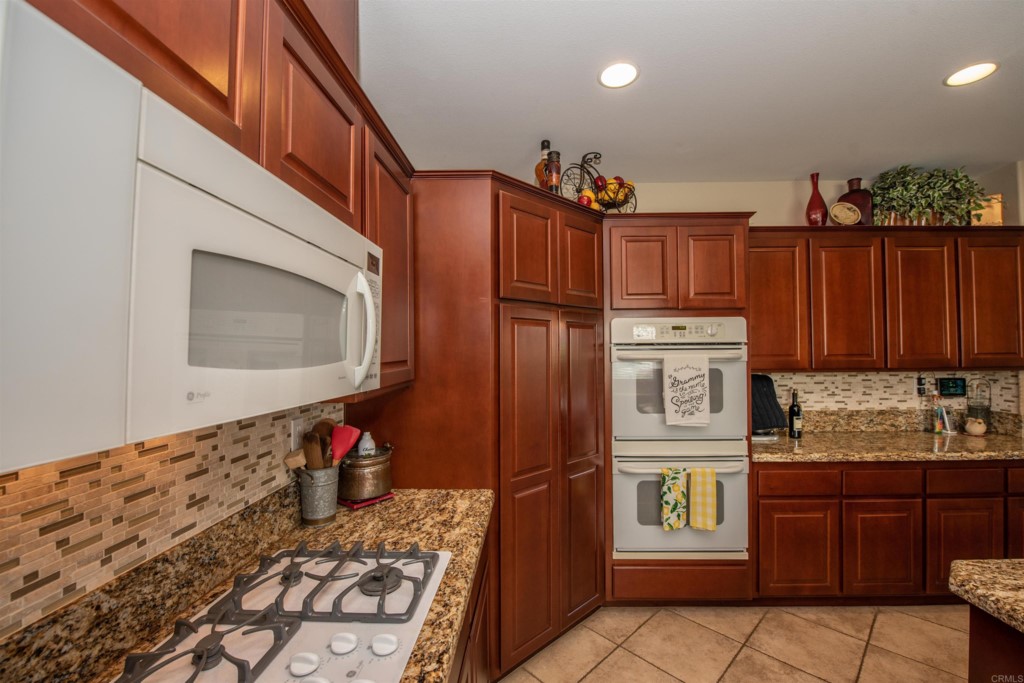 28288 Deep Canyon Drive Escondido, CA 92026 - Photo 18 of 75 a kitchen with stainless steel appliances granite countertop a refrigerator and a stove top oven
