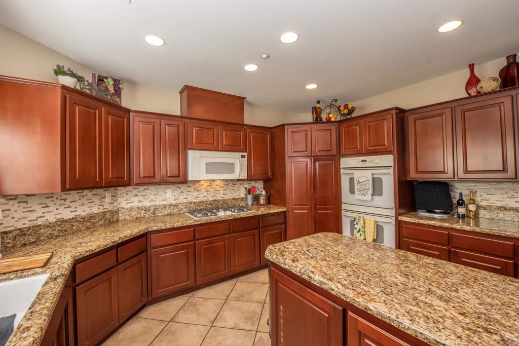 28288 Deep Canyon Drive Escondido, CA 92026 - Photo 20 of 75 a kitchen with stainless steel appliances granite countertop a sink stove and refrigerator
