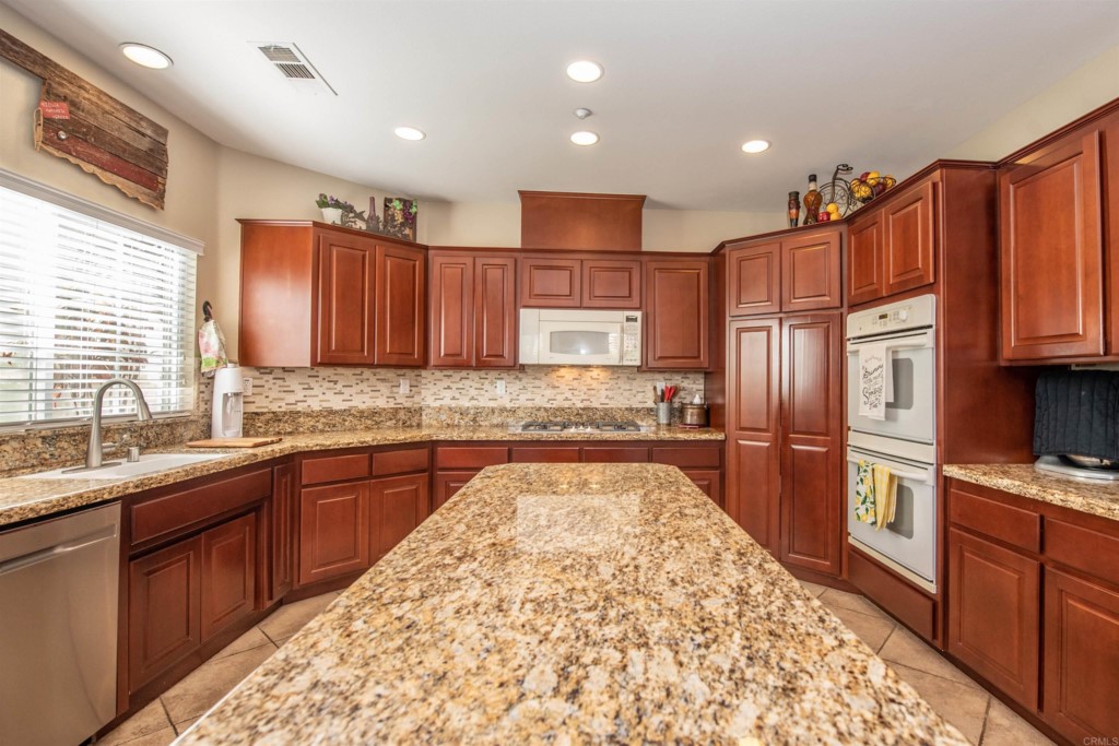 28288 Deep Canyon Drive Escondido, CA 92026 - Photo 23 of 75 a kitchen with stainless steel appliances granite countertop a refrigerator sink and cabinets