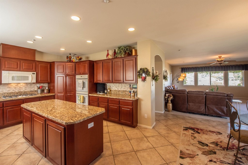 28288 Deep Canyon Drive Escondido, CA 92026 - Photo 25 of 75 a kitchen with stainless steel appliances granite countertop a stove and a refrigerator