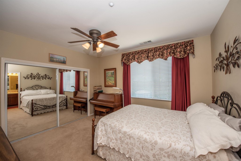 28288 Deep Canyon Drive Escondido, CA 92026 - Photo 48 of 75 a bedroom with a bed and a chandelier