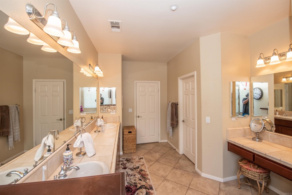 28288 Deep Canyon Drive Escondido, CA 92026 - Photo 61 of 75 a spacious bathroom with a double vanity sink a mirror and a bathtub
