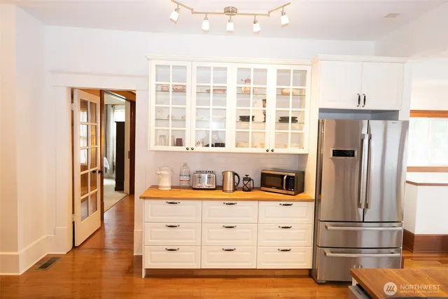 a kitchen with stainless steel appliances a refrigerator and wooden floor