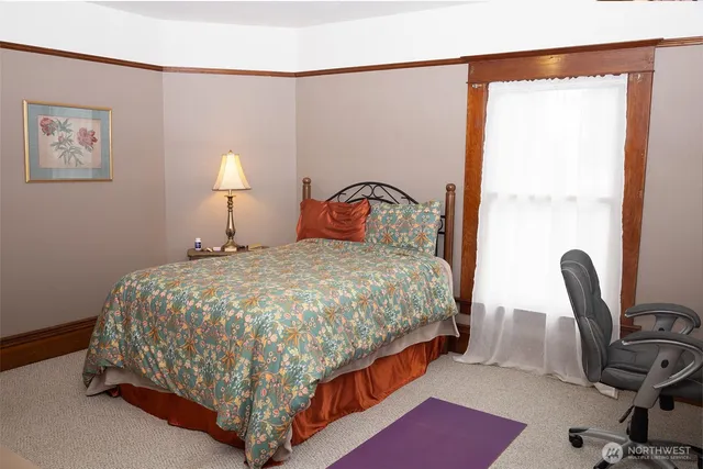 a bed sitting in a bedroom next to a window