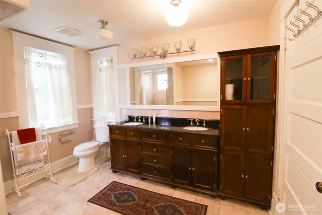 a bathroom with a sink a toilet and a large mirror