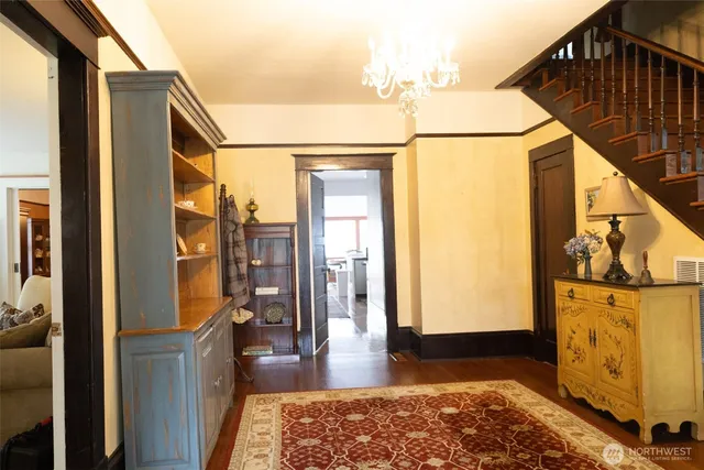 a view of a hallway with wooden floor and furniture
