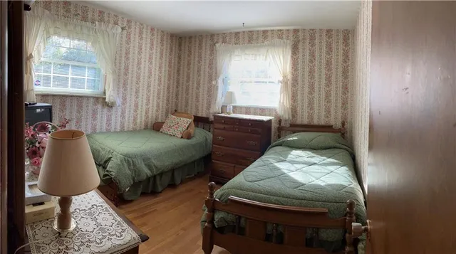 a bedroom with 2 bed and window