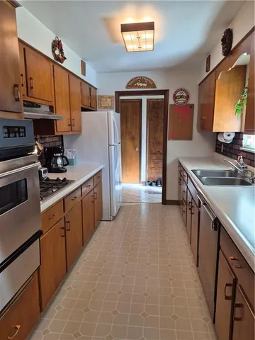 a kitchen with stainless steel appliances a sink stove and refrigerator