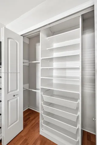 a view of walk in closet with empty racks
