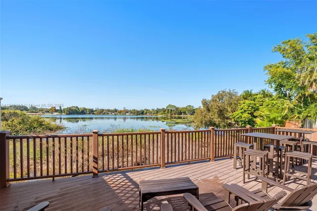 a view of a chairs on wooden deck with lake view