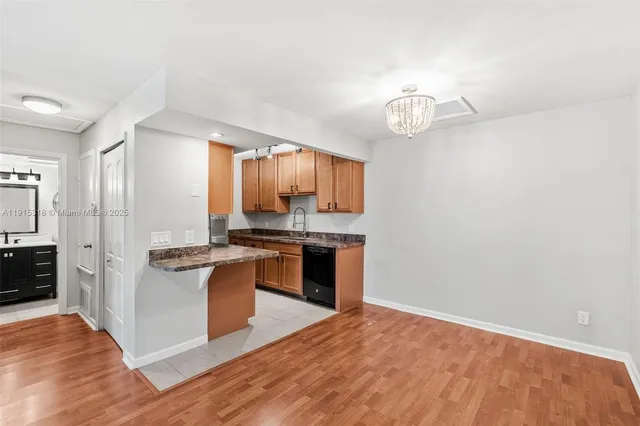 a kitchen with stainless steel appliances granite countertop a refrigerator a stove a sink and a wooden floors