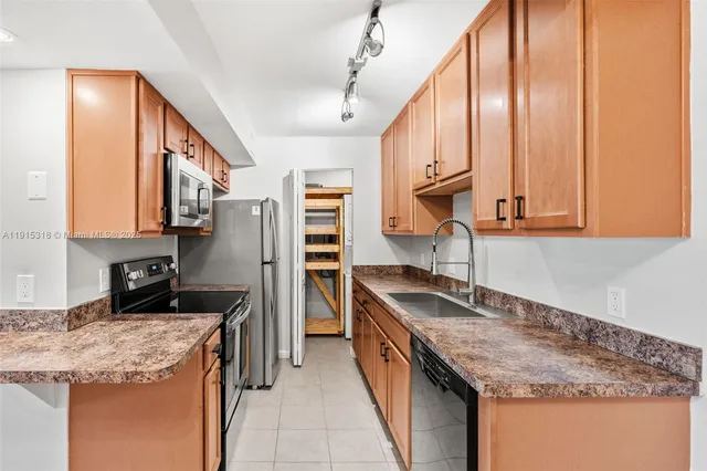 a kitchen that has a sink a stove and a microwave