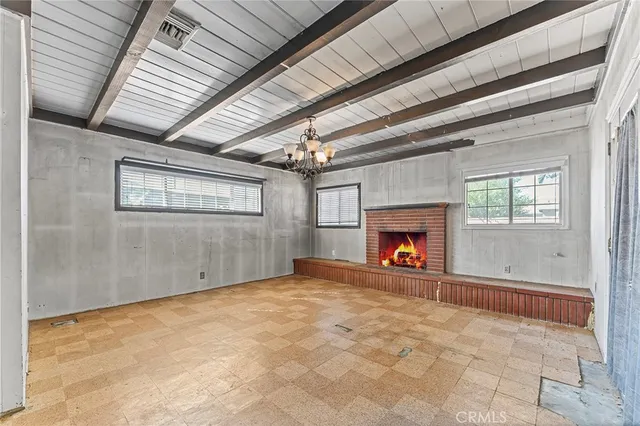 a view of an empty room with a fireplace and a window